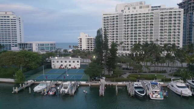 Aerial glide over a miami beach waterway lined with towers and moored yachts