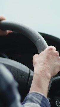 Woman Drives A Car Under Cloudy Skies Hands Gripping The Steering Wheel
