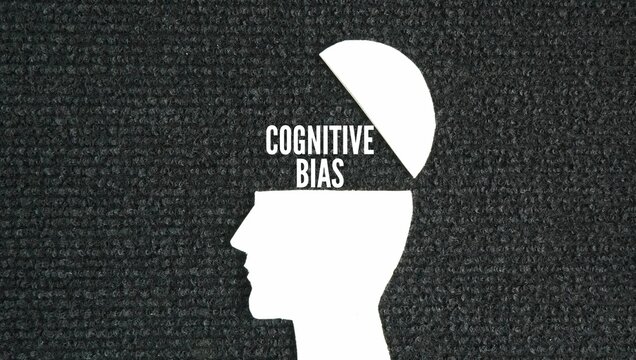 magnifying glass with brain icon and the word Cognitive bias. systematic patterns of deviation from norm or rationality in judgment