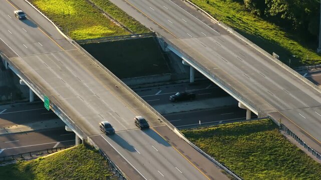 Wide multilane expressway crossroad with overpass ramps and flowing traffic in rural American landscape