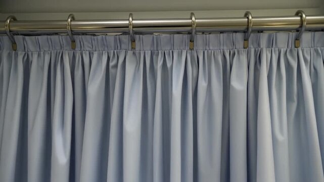 Hospital curtain swaying on its hooks