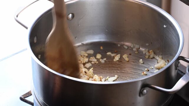 Adding sliced butternut squash into a hot pot to make butternut squash soup, homemade food in autumn