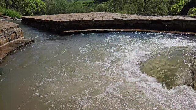 Glittering spring water swells into a foaming dome in a round stone pool, with lush green trees, rolling hills, distant mountains and fluffy white clouds.
📍Ghol Spring, Sarvabad, Kurdistan 
