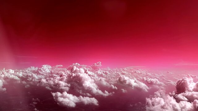 Flying through the clouds aerial view from airplane red sky