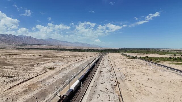 winding railway tracks traversing the desert landscape under blue sky