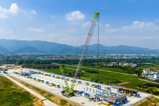 Large crawler crane conducting lifting operations at a construction site with panoramic view