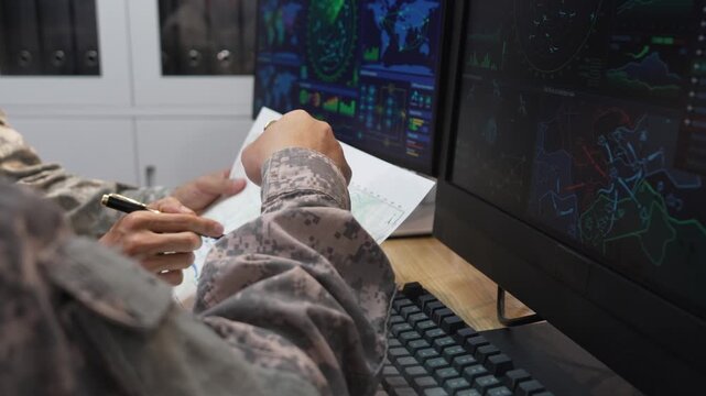 Military Officers Analyzing Tactical Map and Radar Display Monitors in Command Center