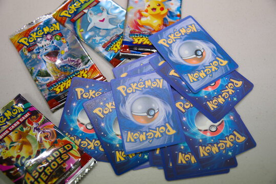 Semaphore, South Australia - July 22 2026: Counterfeit trading card game merchandise including booster packs and multiple blue-backed collector cards on a white surface