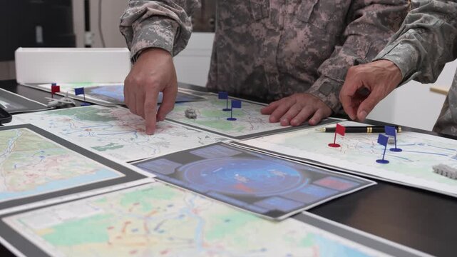 Military Officers Planning Battle Strategy using Tactical Map, Flags and Models on Table