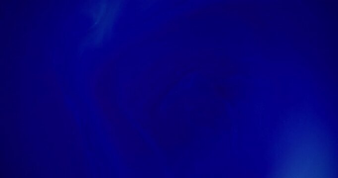 Defocused navy ink. Vibrant fluid spill. Blue color shiny wet texture bright water pigment acrylic liquid floating on abstract background.