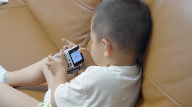 Overhead view of toddler interacting with AI voice assistant robot