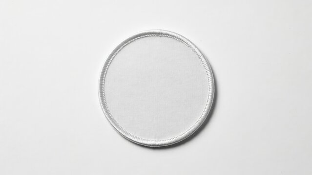 A blank white round embroidered patch mockup is isolated on white background. Use this flat lay for custom apparel branding.