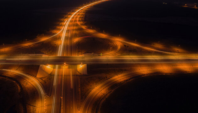 Aerial long exposure of busy highway junction at night