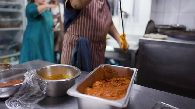 Indian Chef Threading Marinated Chicken Tikka onto Skewer in Kitchen
