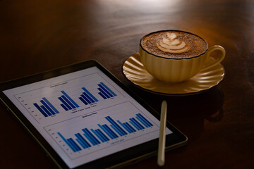Business Planning with Data Analytics Tablet and Latte Coffee on Wooden Table © nuraporn