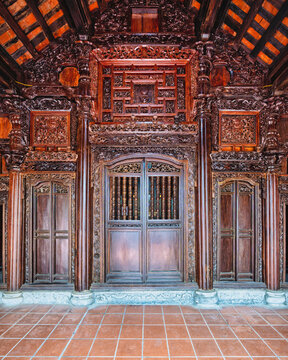 Ornate wooden architecture featuring intricate carvings at Phat Diem Cathedral in Ninh Binh, Vietnam