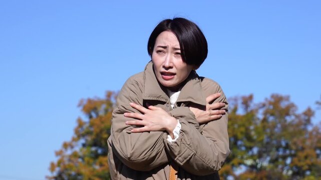 外で凍えるミドルエイジの女性