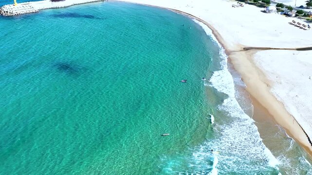 Aerial top-down view of beautiful emerald ocean waves breaking on a white sand beach in South Korea.