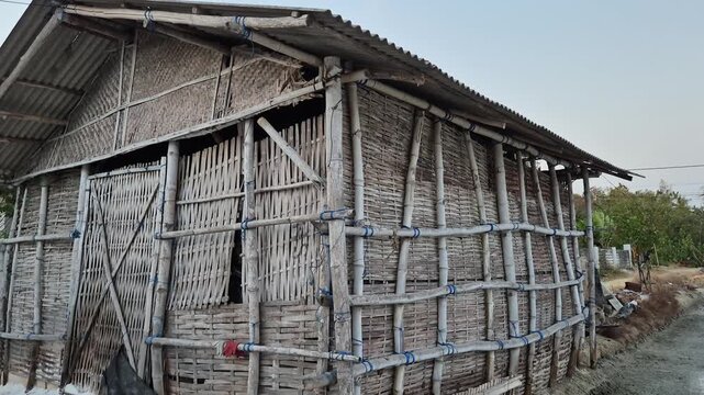 Tilt up shot of a traditional bamboo hut used for salt storage in a rural coastal village.