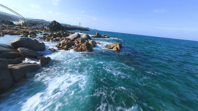 Dynamic fast-speed FPV drone shot flying low over heavy ocean waves in South Korea East Sea.