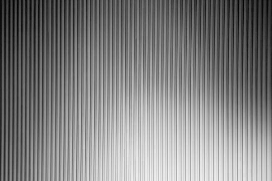 Vertical grey corrugated metal wall panel texture background with neat parallel lines.