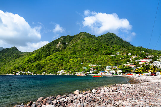 Beautiful coastline of Scotts Head village with lush green mountains and pebble beach along Soufriere Bay in Dominica, Caribbean.