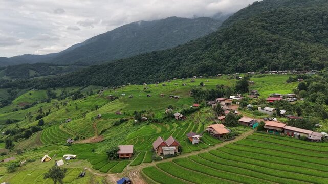Aerial landscape view of wooden huts in the rice terrace and mountains