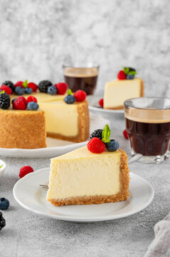 Classic American cheesecake New York with fresh berries on top on a white plate on a concrete background. Copy space, top view.