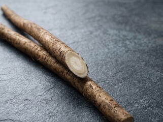 Obraz premium Burdock roots sliced on dark stone kitchen countertop