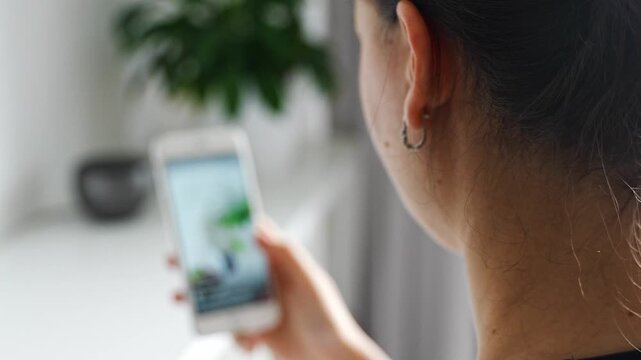 Woman scrolling social media on a smartphone at home. Digital addiction concept with endless content consumption and screen time.