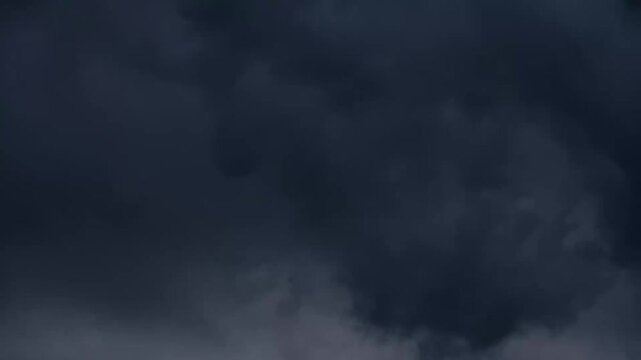 dark storm clouds rolling across the sky with a single lightning strike