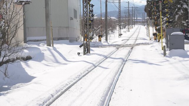 晴天の青空と深い雪に覆われたローカル線の駅のホームと待合室