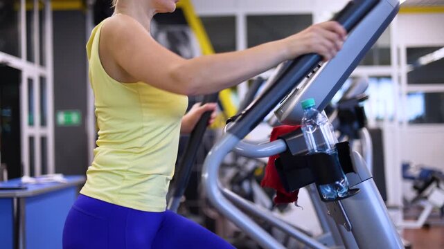 Watch this inspiring cropped footage of a middle-aged woman engaged in a cardio workout on a step machine, showcasing her dedication to fitness and the importance of maintaining a healthy lifestyle.