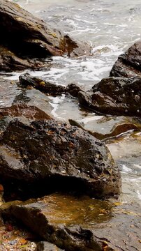 Ocean Waves Crashing Over Dark Coastal Rocks on Rocky Shore