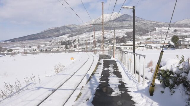 晴天の青空と深い雪に覆われたローカル線の駅のホームと待合室