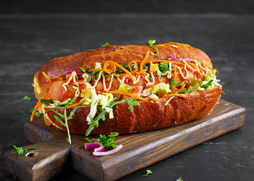 Premium Hot Dog with Fresh Ingredients on Dark Table