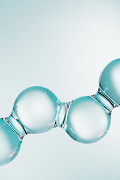 Abstract blue molecules on light vertical background. 3D render of glossy liquid molecular structure, science and skincare concept with transparent spheres and copy space for modern design.
