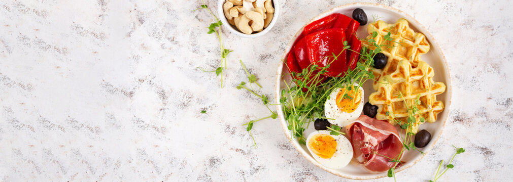 English breakfast. Boiled egg, jamon, waffles and green herbs. Top view, flat lay