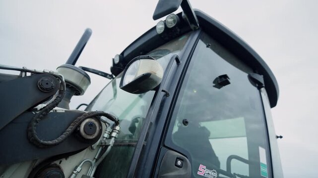 Flashing amber lamp on excavator cabin warns about work at construction site. Modern building machinery used to maintain trenches in ground