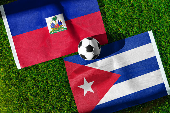 Haiti vs. Cuba football match. National flags on green grass with soccer ball in the middle. Football background for international match.