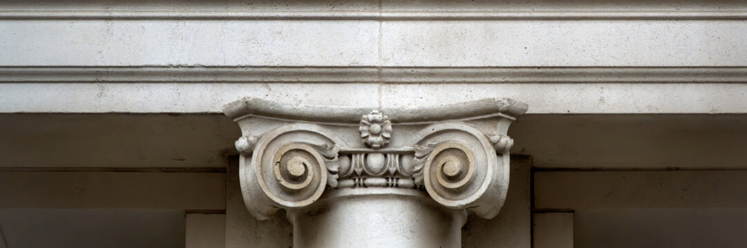 Panorama of architectural detail on concrete Victorian Ionic column in London