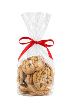 Delicious chocolate chip cookies are neatly packaged in a clear cellophane bag tied with a vibrant red ribbon, isolated on a white background