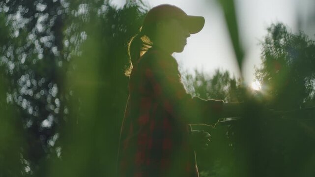 Young woman fly fishing on the small shallow river during summer day