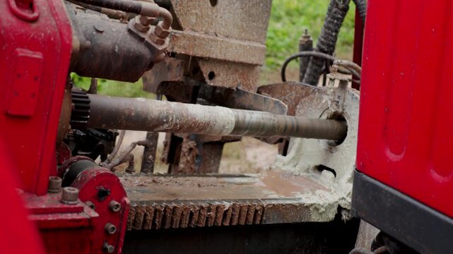 Rotating bore of coiled tubing rig drilling hole in ground at construction site. Modern machinery prepares trenches for communication systems