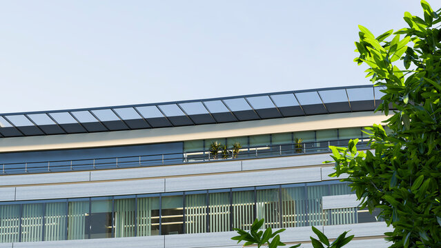 Modern office building with glass balcony and potted plants