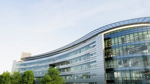 Modern curved office building with glass facade and trees