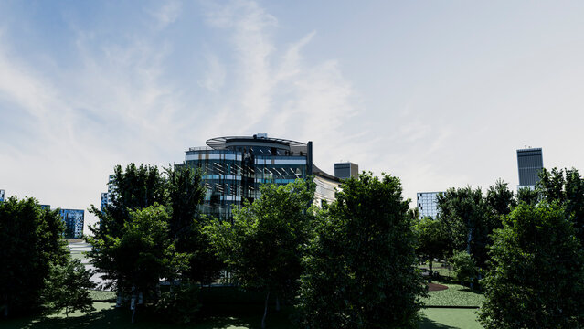 Modern office building with glass facade and trees in urban setting