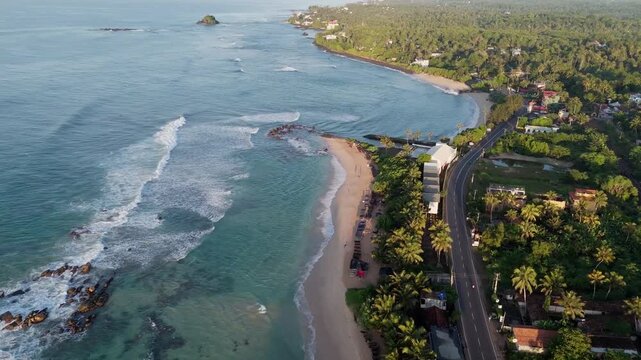 Cinematic aerial drone shot flying forward in beautiful morning light over midigama beach and the famous lazy left surf break in Sri Lanka
