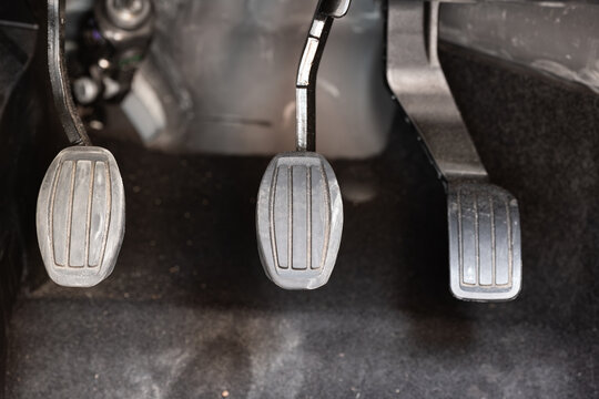 Car pedal set including clutch brake and accelerator pedals inside driver footwell of manual transmission vehicle