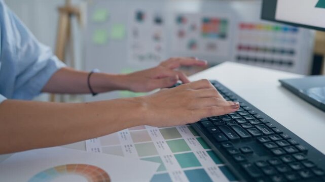 Close up of female designer working on a table in a creative workspace. 